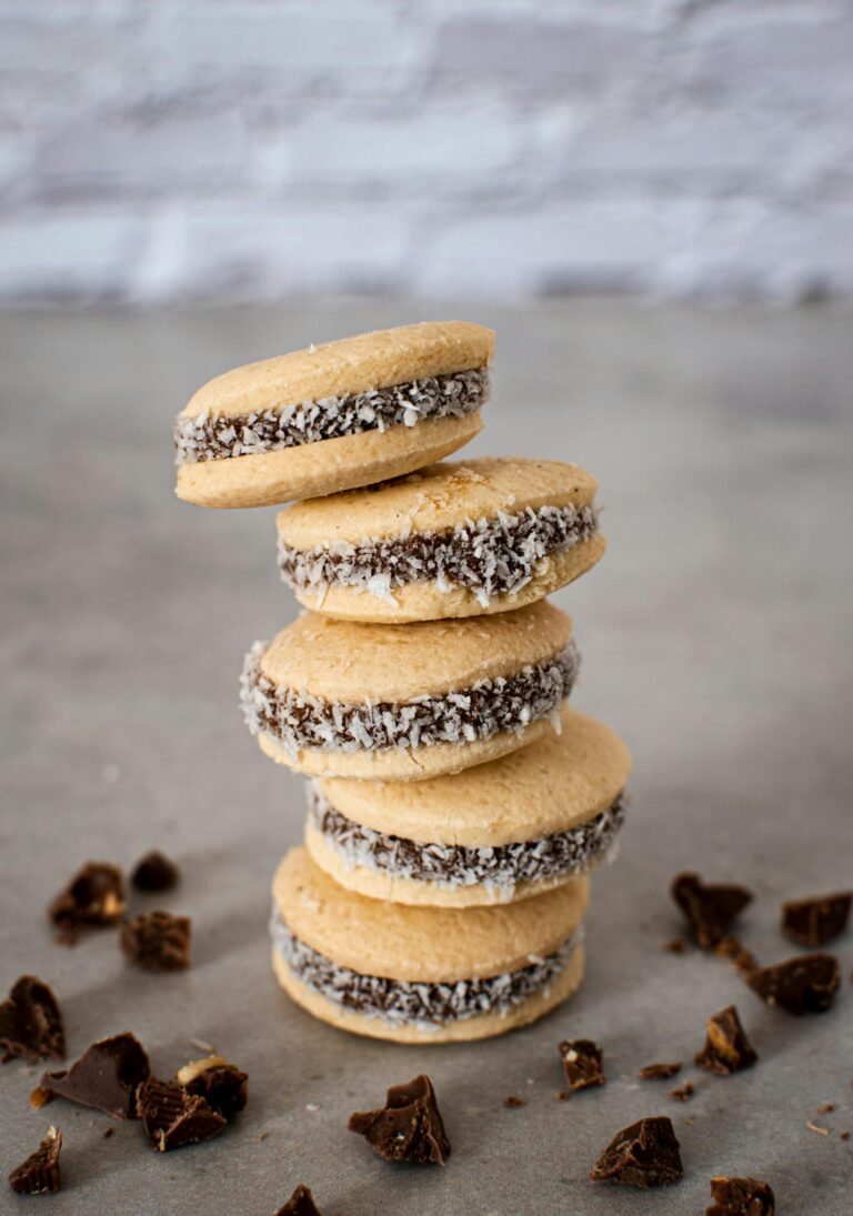 A neat stack of traditional Argentinian alfajores with dulce de leche filling and coconut flakes.